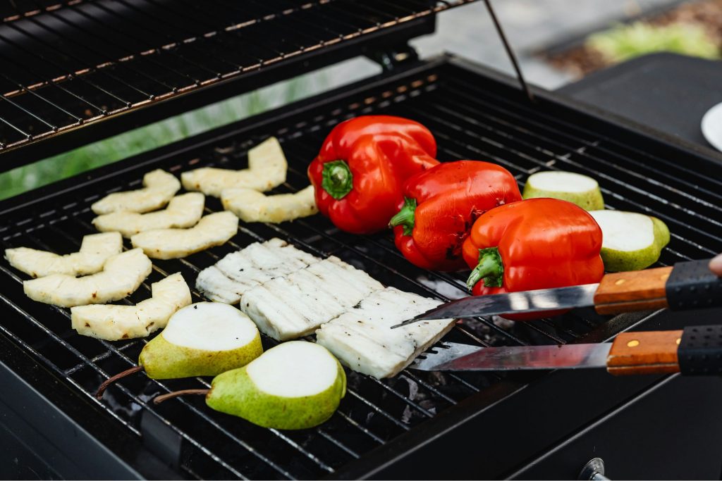 Vegetarisch Grillen: Ein Grill, auf dem Obst und Gemüse liegen
