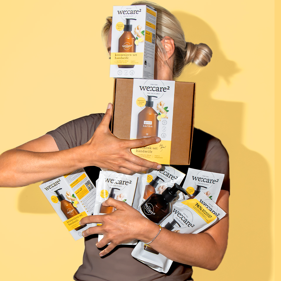 Blonde Frau hat die Arme voll mit we care Produkten - Seife mit Suchtfaktor